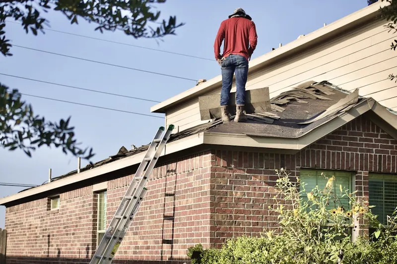 Professional roofer working on a residential roof in Ford